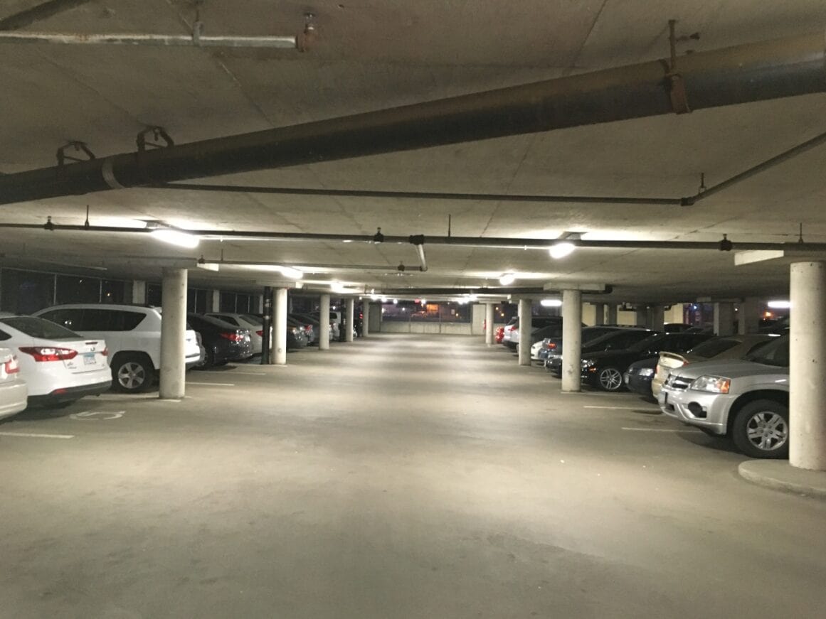 a parking garage with cars parked in pleasant lighting