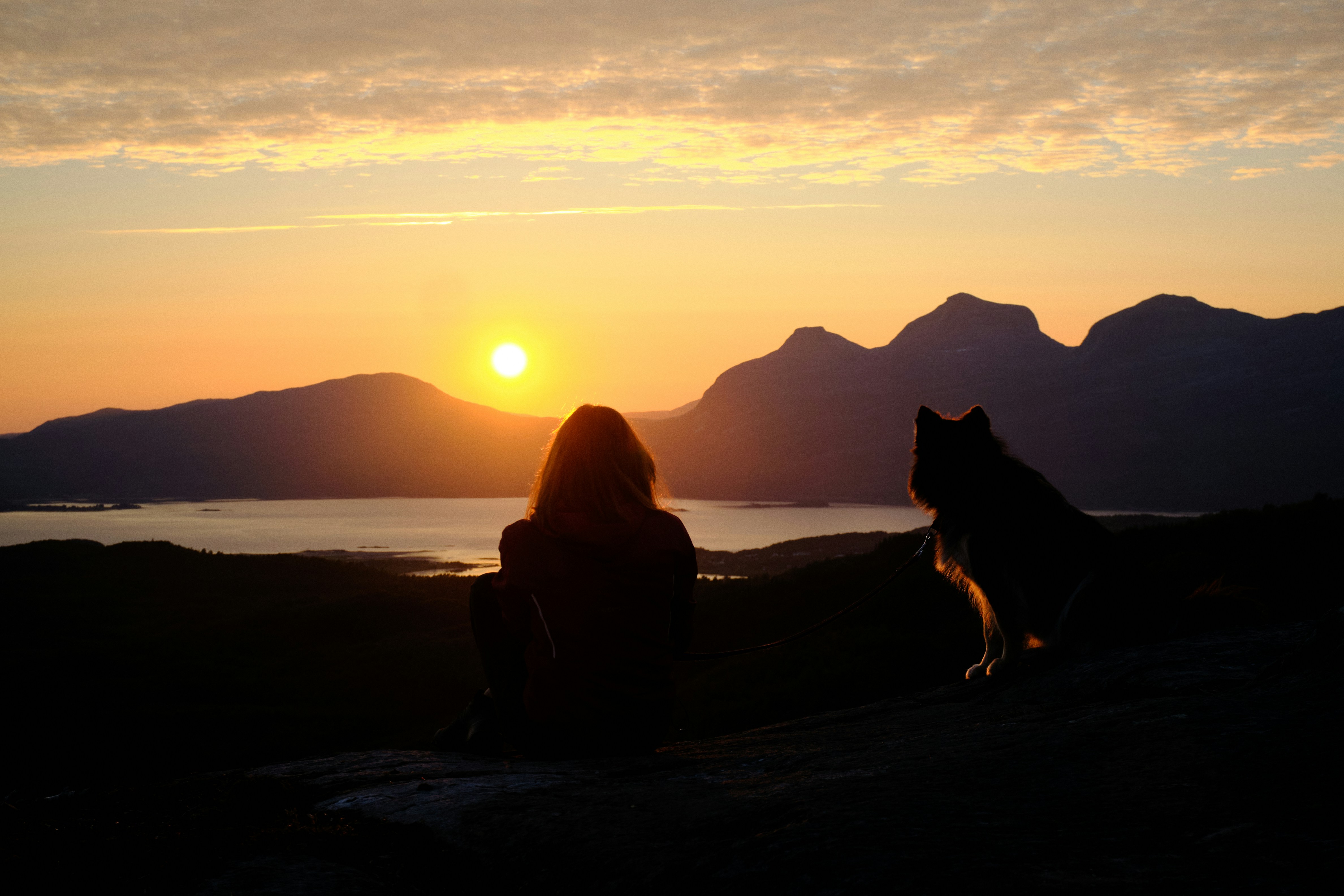 Woman with dog at sunrise representing reclamation, freedom, and gentle power