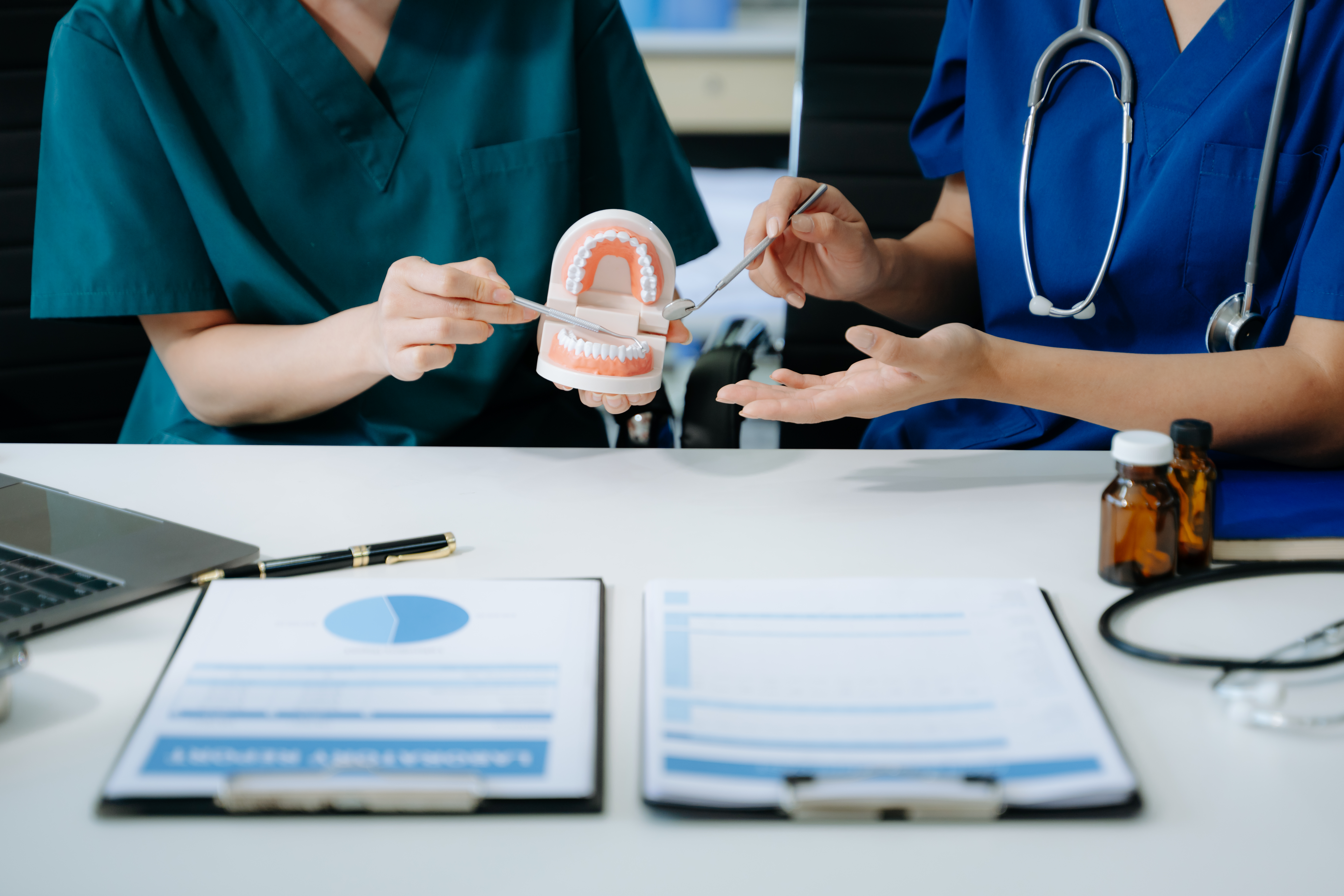 Dentists talking to a patient after successfully landing them through innovative digital dental marketing system.