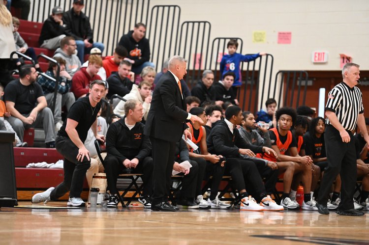 Kody Hartlaub coaching Central York basketball players on the sideline during a high school game, emphasizing strategy and mental conditioning