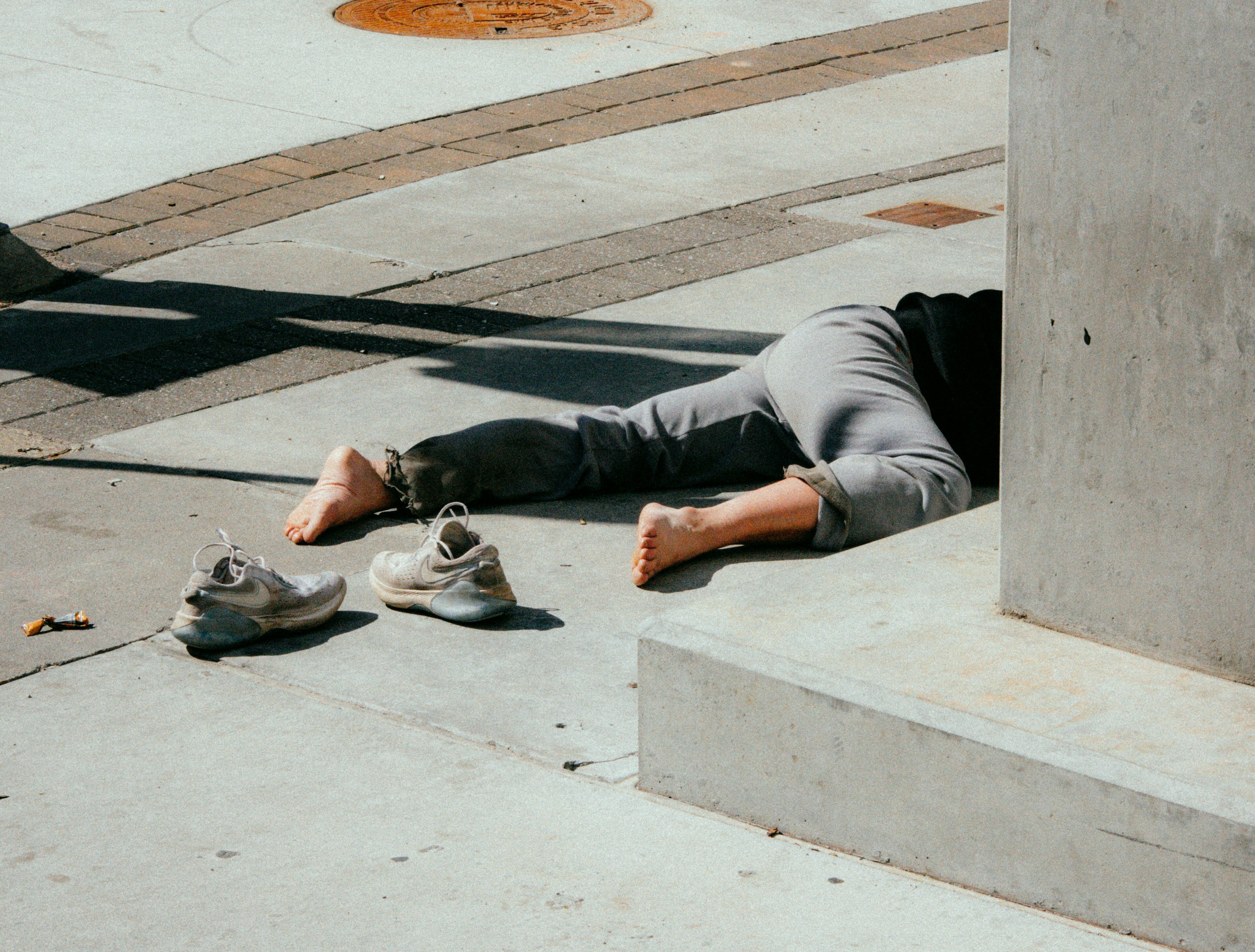 A person rests on the ground, eyes closed, in a peaceful outdoor environment, suggesting tranquility and relaxation. A person rests on the ground, eyes closed, in a peaceful outdoor environment, suggesting tranquility and relaxation.