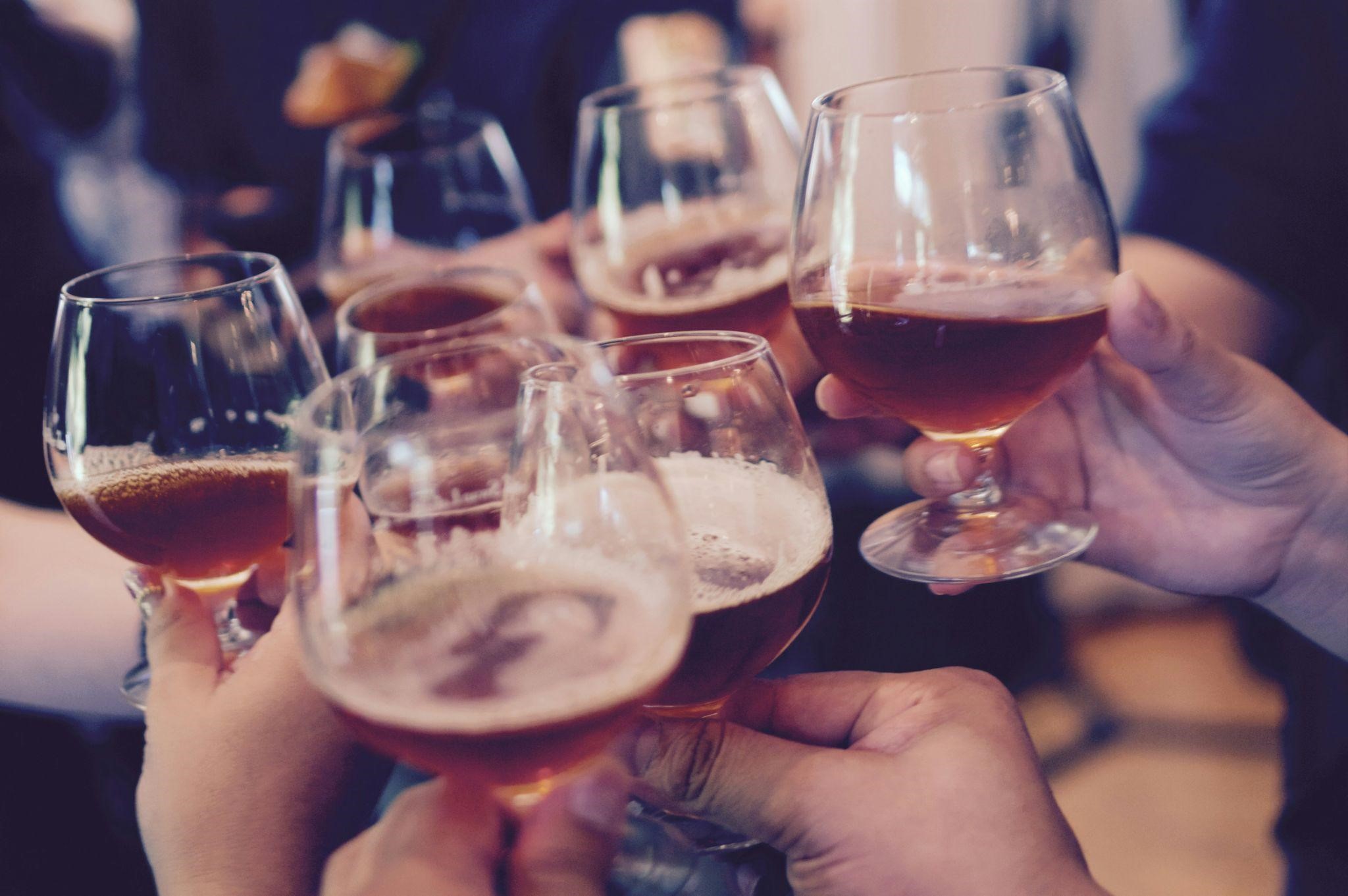 A diverse group of people cheerfully holding beer glasses, celebrating together in a festive social setting. A diverse group of people cheerfully holding beer glasses, celebrating together in a festive social setting.