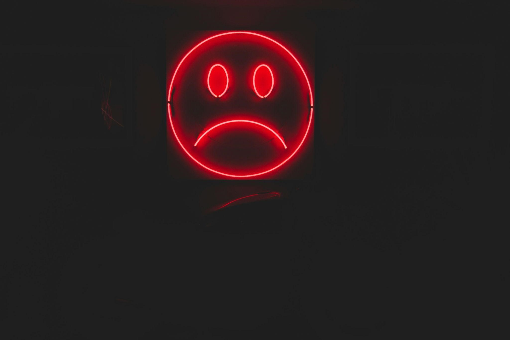 A red smiley face on a solid black background, conveying a cheerful and playful expression. A red smiley face on a solid black background, conveying a cheerful and playful expression.