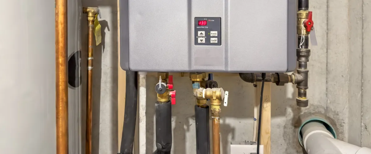 Installed tankless water heater with visible pipes and control panel Installed tankless water heater with visible pipes and control panel