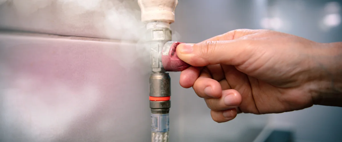 Hand turning a gas shutoff valve during plumbing repair