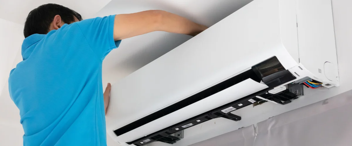 Technician installing wall mounted air conditioner unit