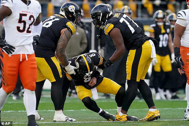 Aaron Rodgers in a Steelers uniform holding his injured wrist, with bold text ‘Wrist Injury’ and Politikanta Minute branding. Aaron Rodgers in a Steelers uniform holding his injured wrist, with bold text ‘Wrist Injury’ and Politikanta Minute branding.