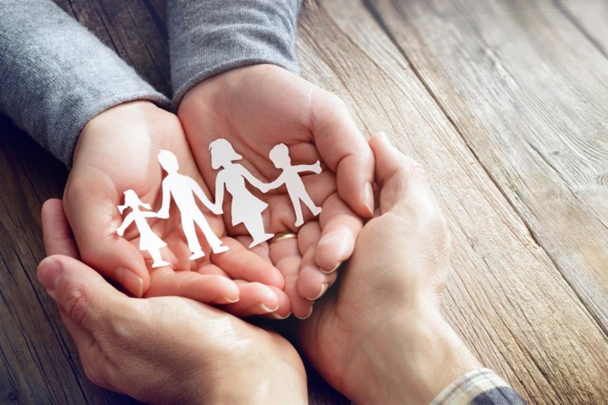 Hands Holding Paper Cutout of Family