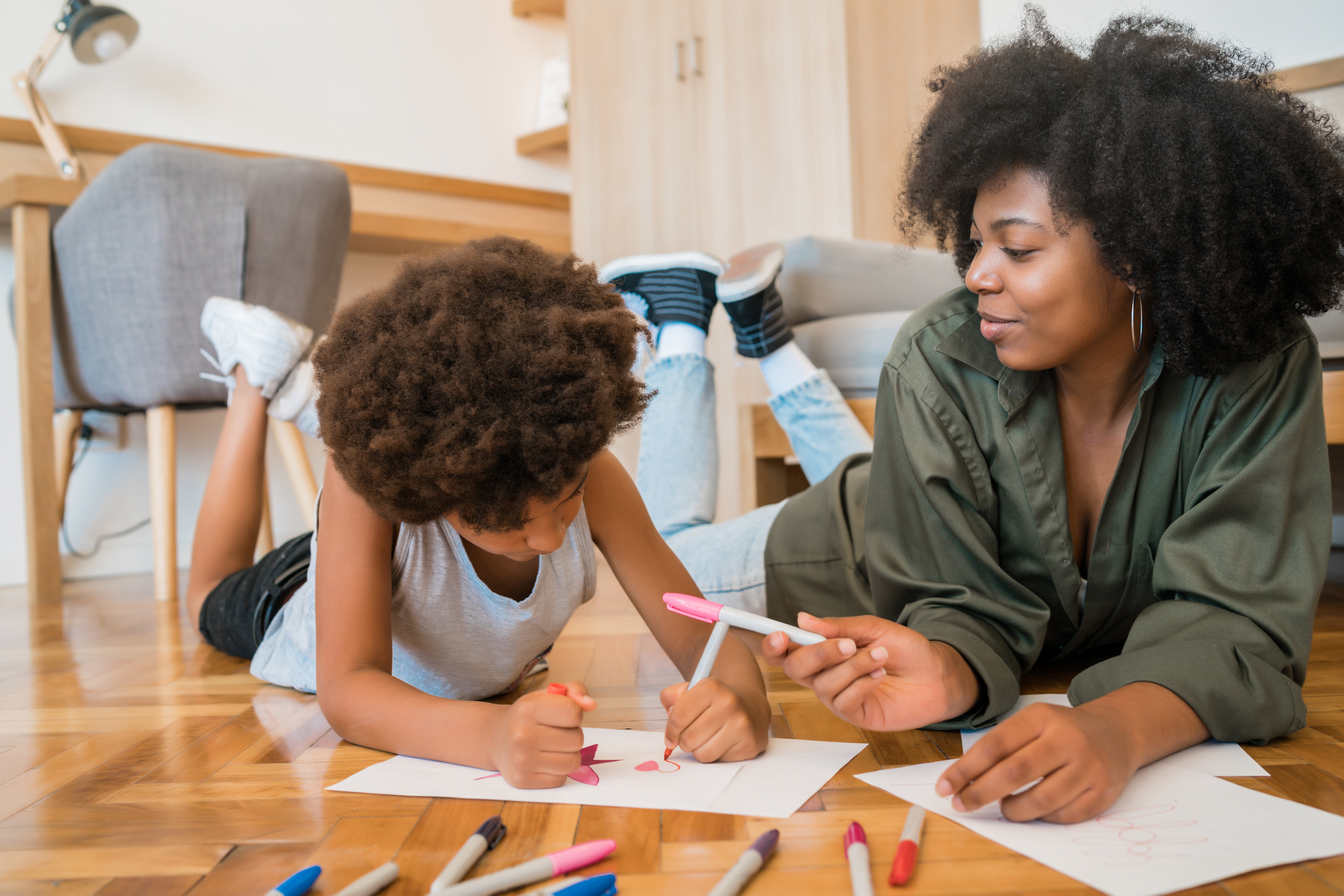 Mom helping her son to write and color.