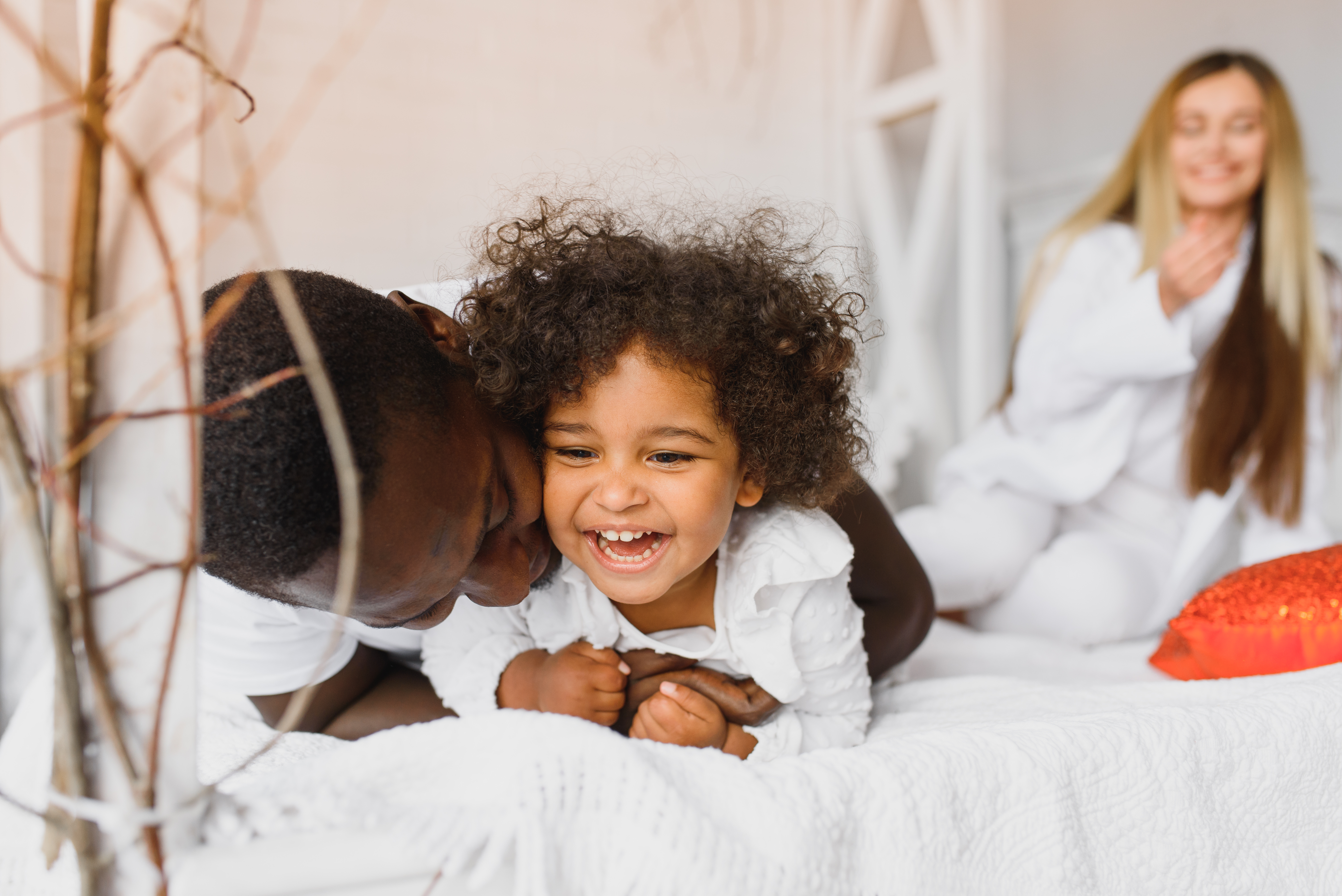 The father is cuddling with his daughter early in the morning. The father is cuddling with his daughter early in the morning.