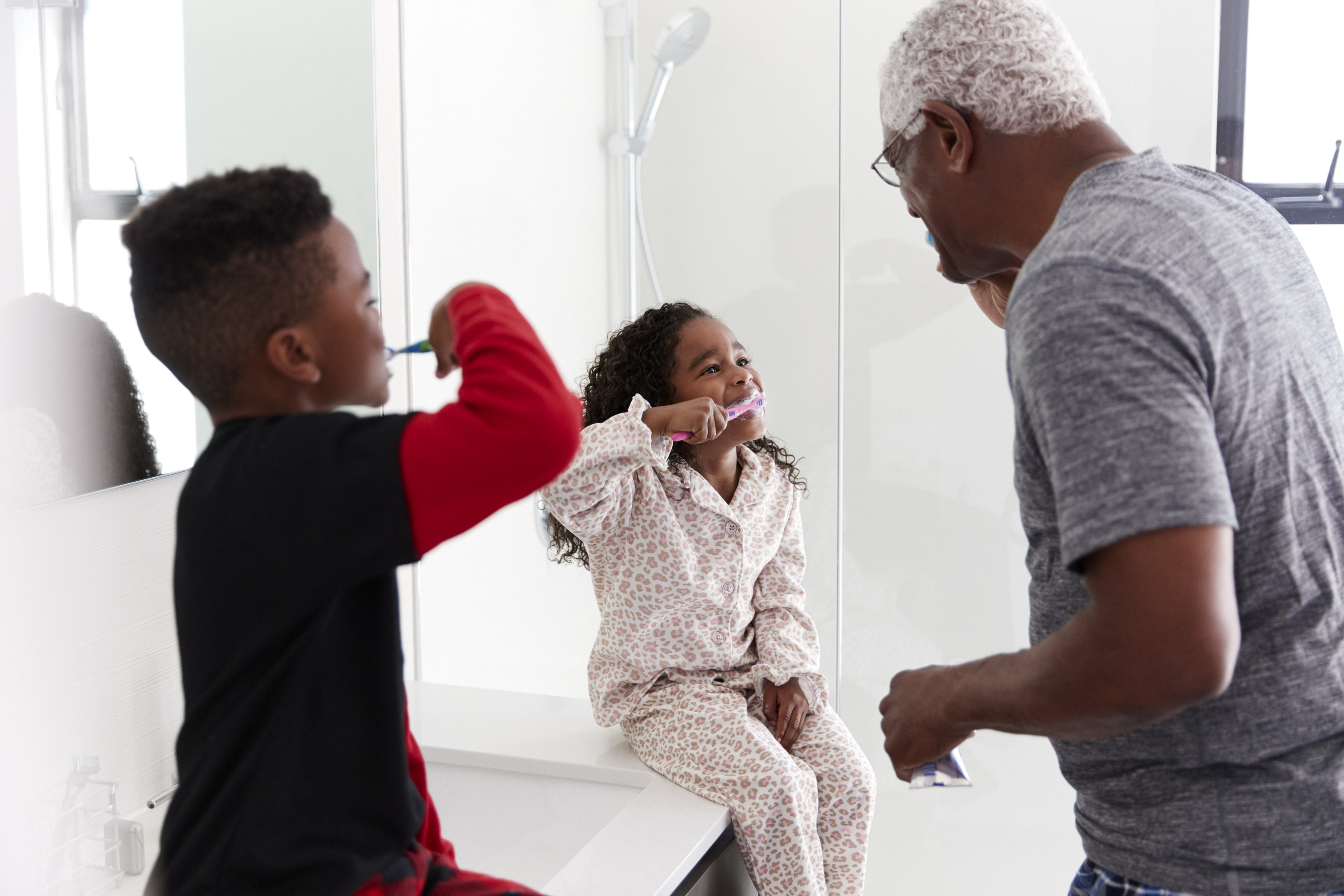 The father makes brushing their children's teeth into a game. The father makes brushing their children's teeth into a game.