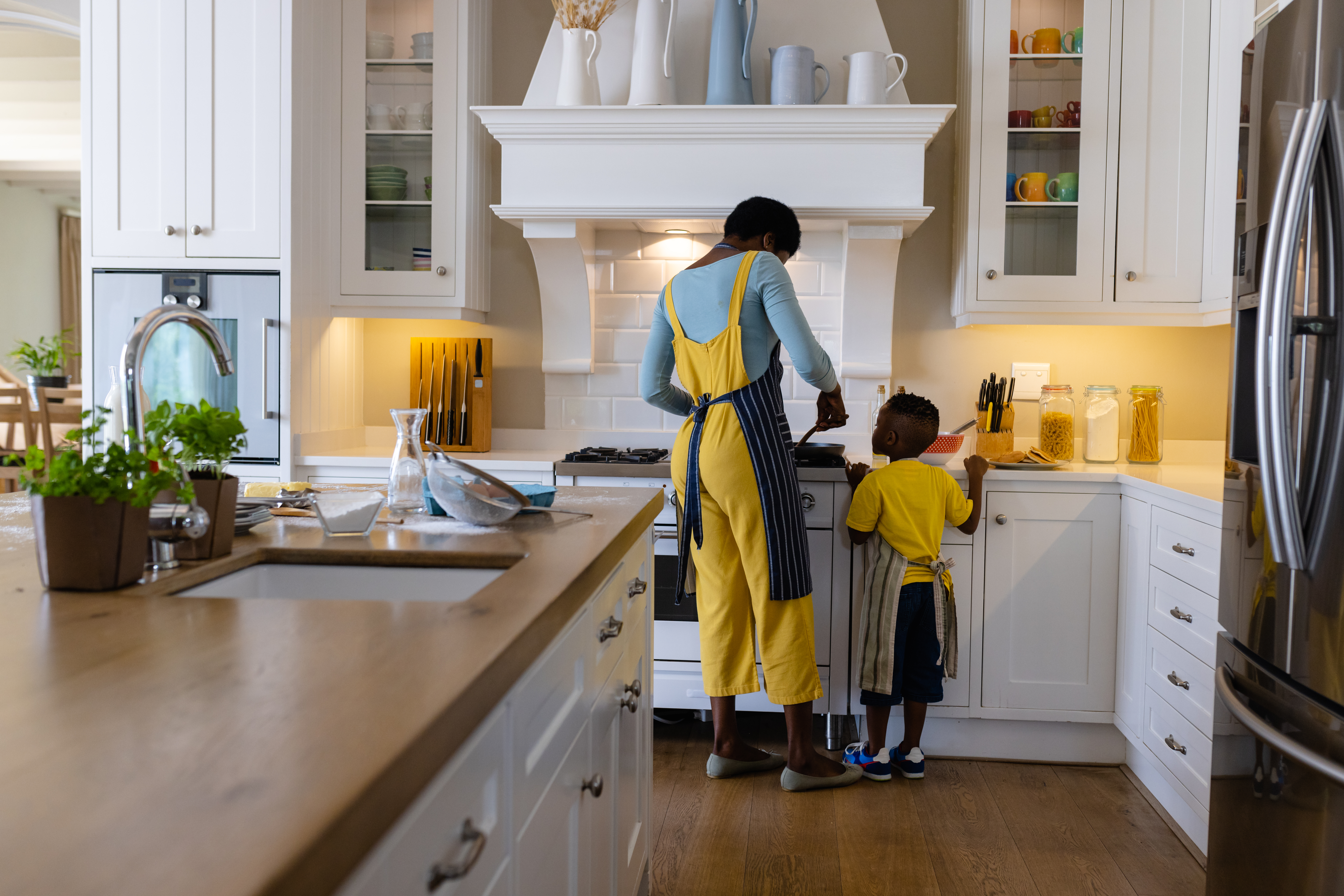The mother warns her child that playing near the stove is not allowed and ensures that the she uses stove knob covers and keeps cleaning supplies locked away. The mother warns her child that playing near the stove is not allowed and ensures that the she uses stove knob covers and keeps cleaning supplies locked away.