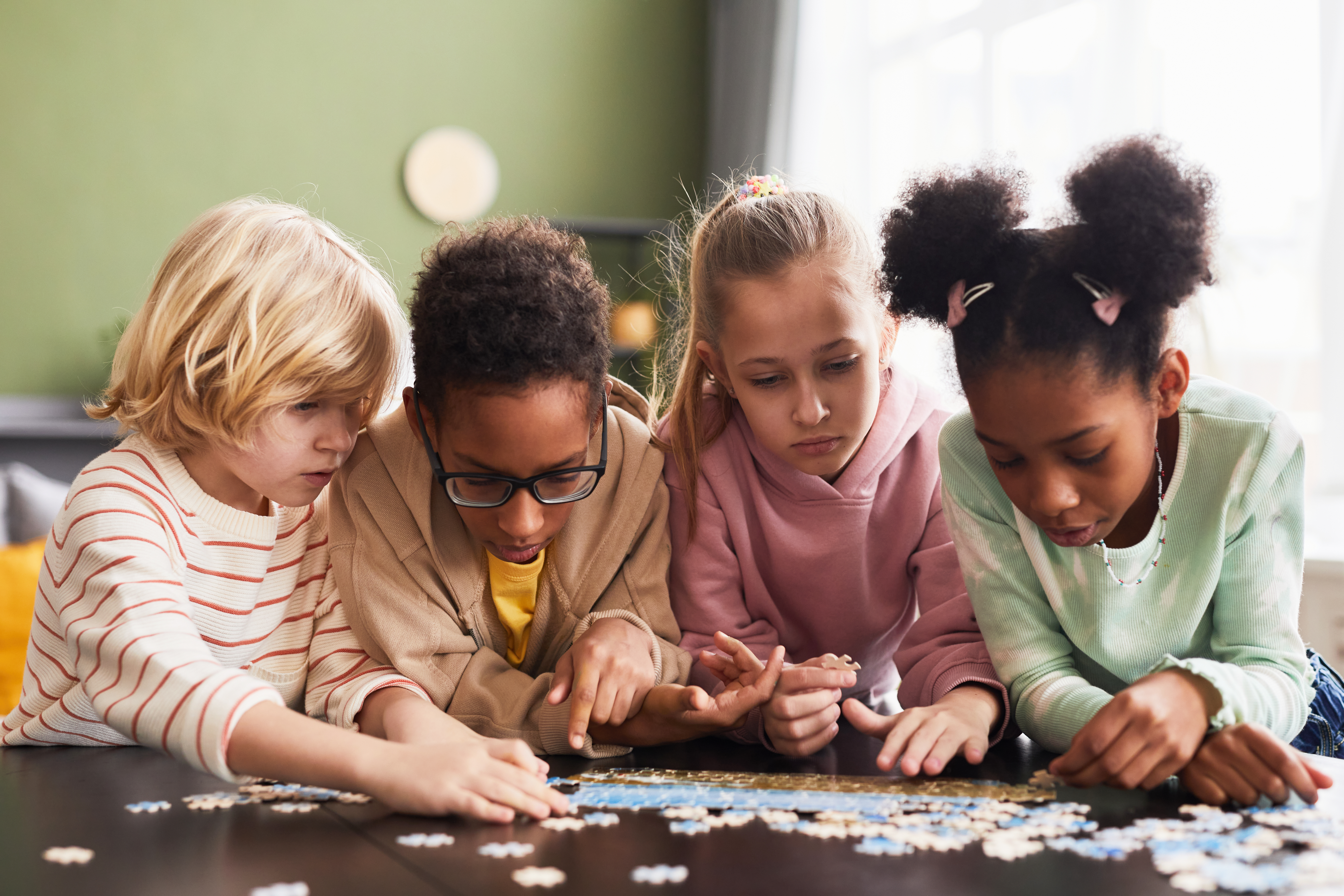 The children patiently work on the puzzle, which helps develop their skills The children patiently work on the puzzle, which helps develop their skills