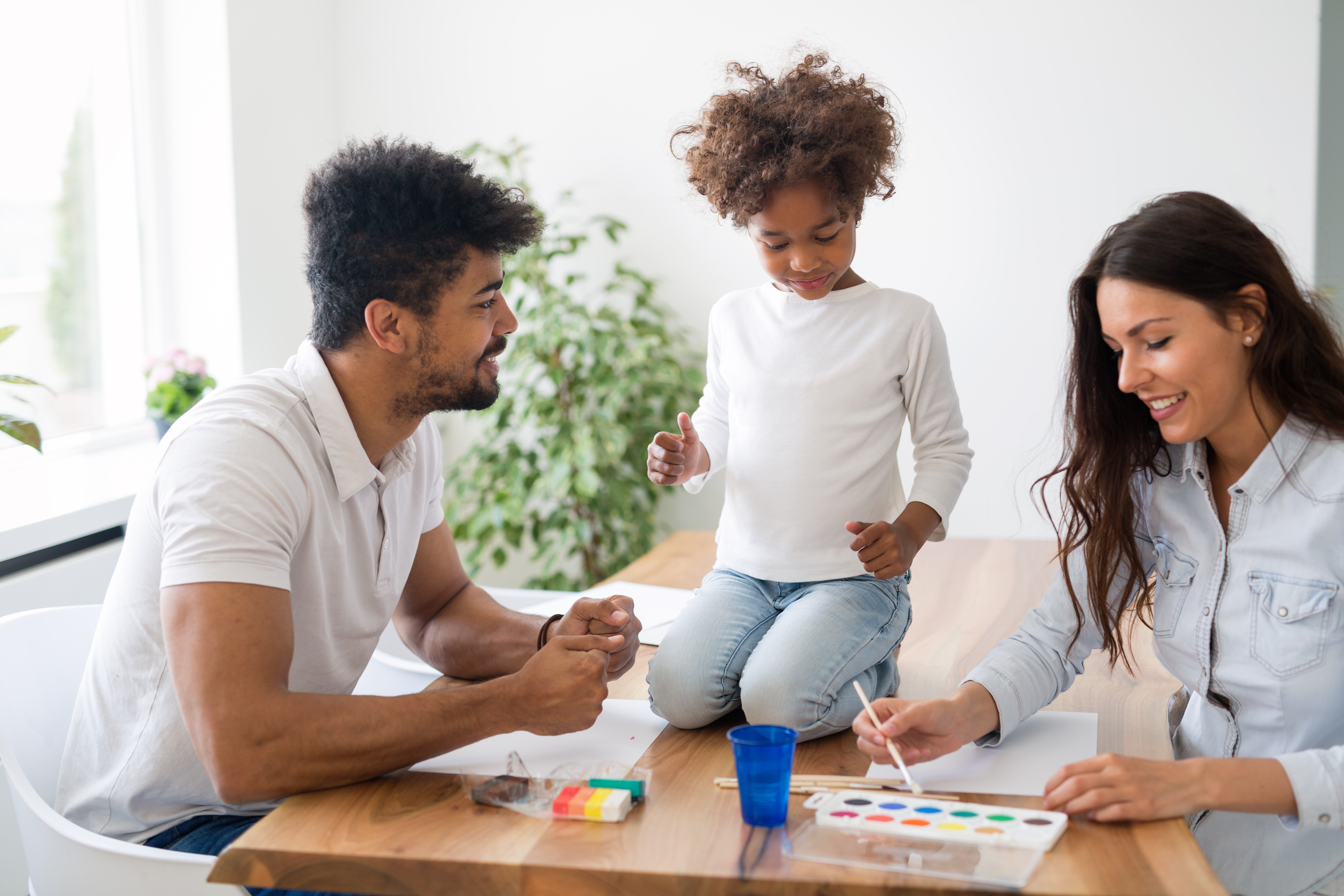 The parents accompany and help their child learn painting. The parents accompany and help their child learn painting.