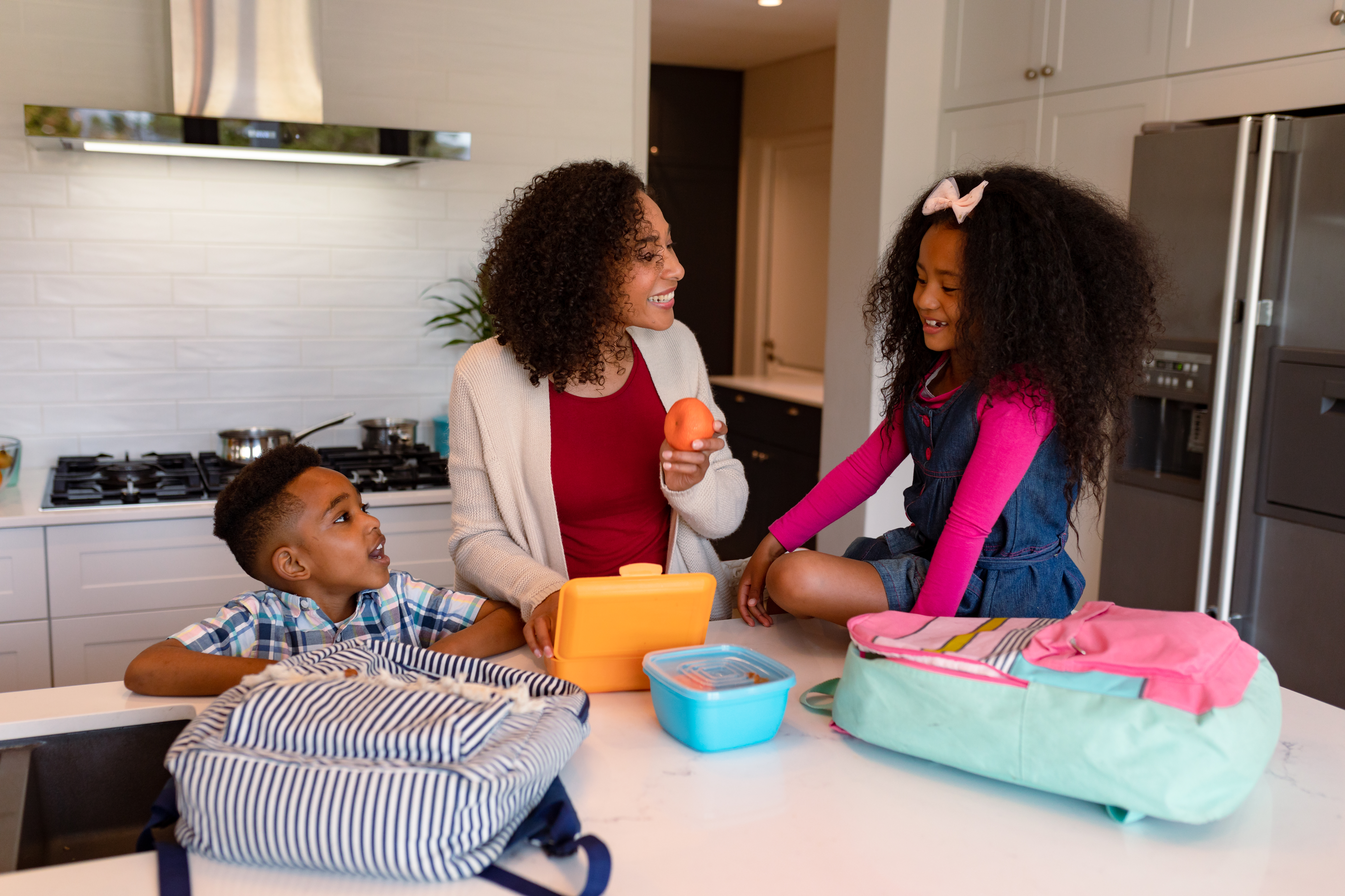 Kids helping their mother prepare their lunch for school