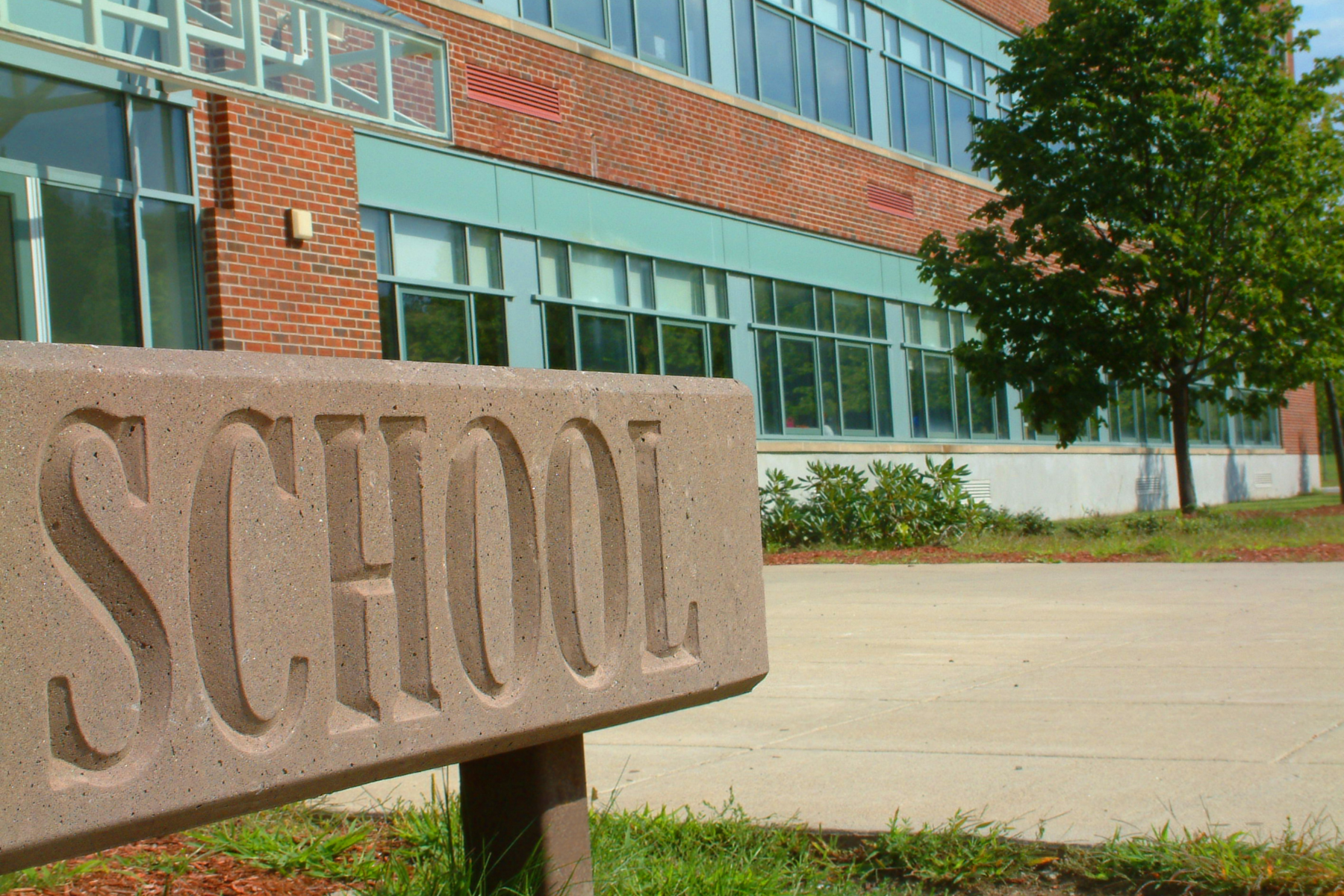 Exterior of a modern public school building in Northern Virginia with a large engraved 'SCHOOL' sign, representing access to quality education and top-rated school districts. Exterior of a modern public school building in Northern Virginia with a large engraved 'SCHOOL' sign, representing access to quality education and top-rated school districts.