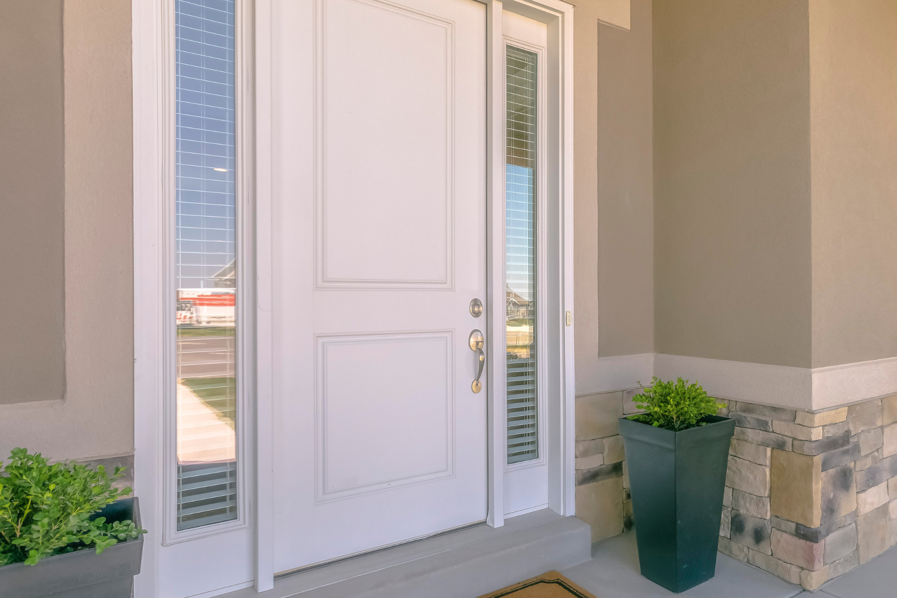 This image highlights a crisp, modern front entry with a clean white door, tall planters, and neutral stonework—demonstrating a polished, move-in-ready look that appeals to today’s buyers. This image highlights a crisp, modern front entry with a clean white door, tall planters, and neutral stonework—demonstrating a polished, move-in-ready look that appeals to today’s buyers.