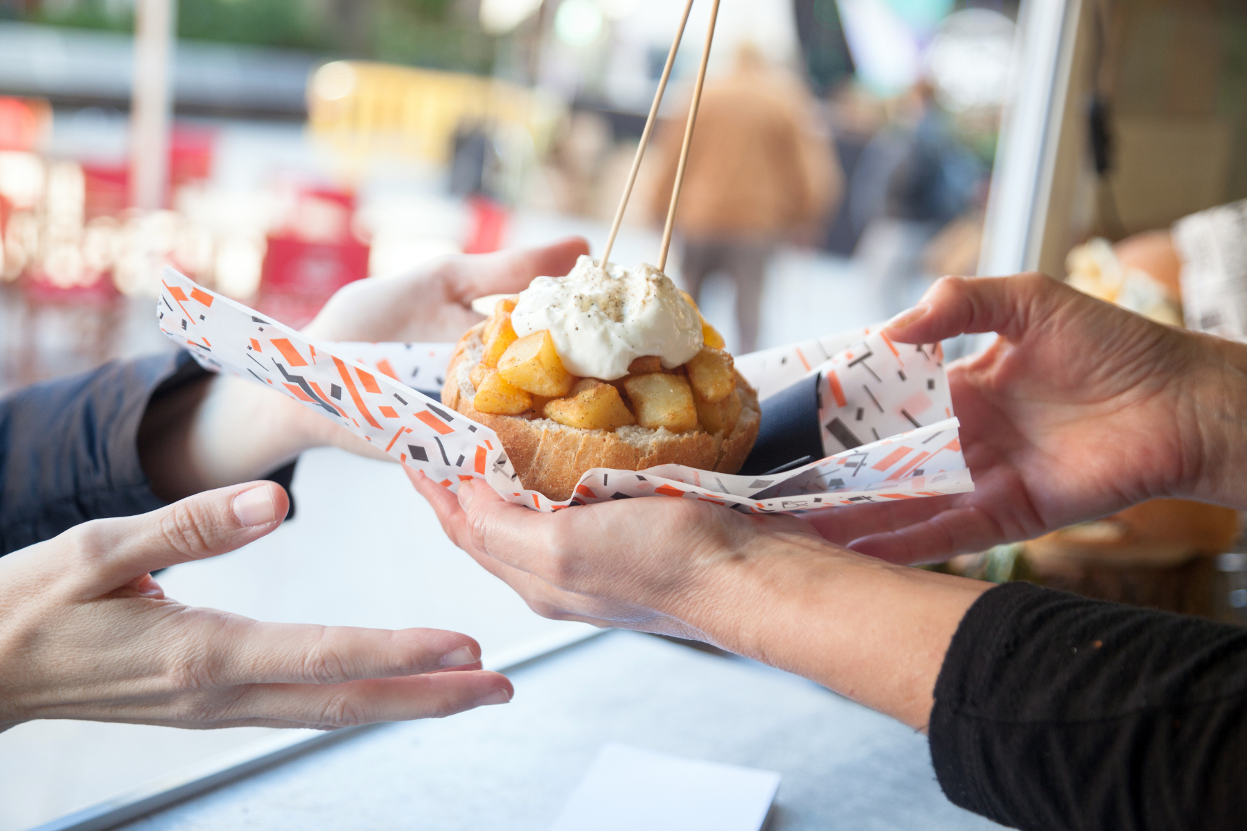 A vendor hands over a freshly made dessert topped with apples and whipped cream, capturing the mouthwatering charm of festival street food. A vendor hands over a freshly made dessert topped with apples and whipped cream, capturing the mouthwatering charm of festival street food.