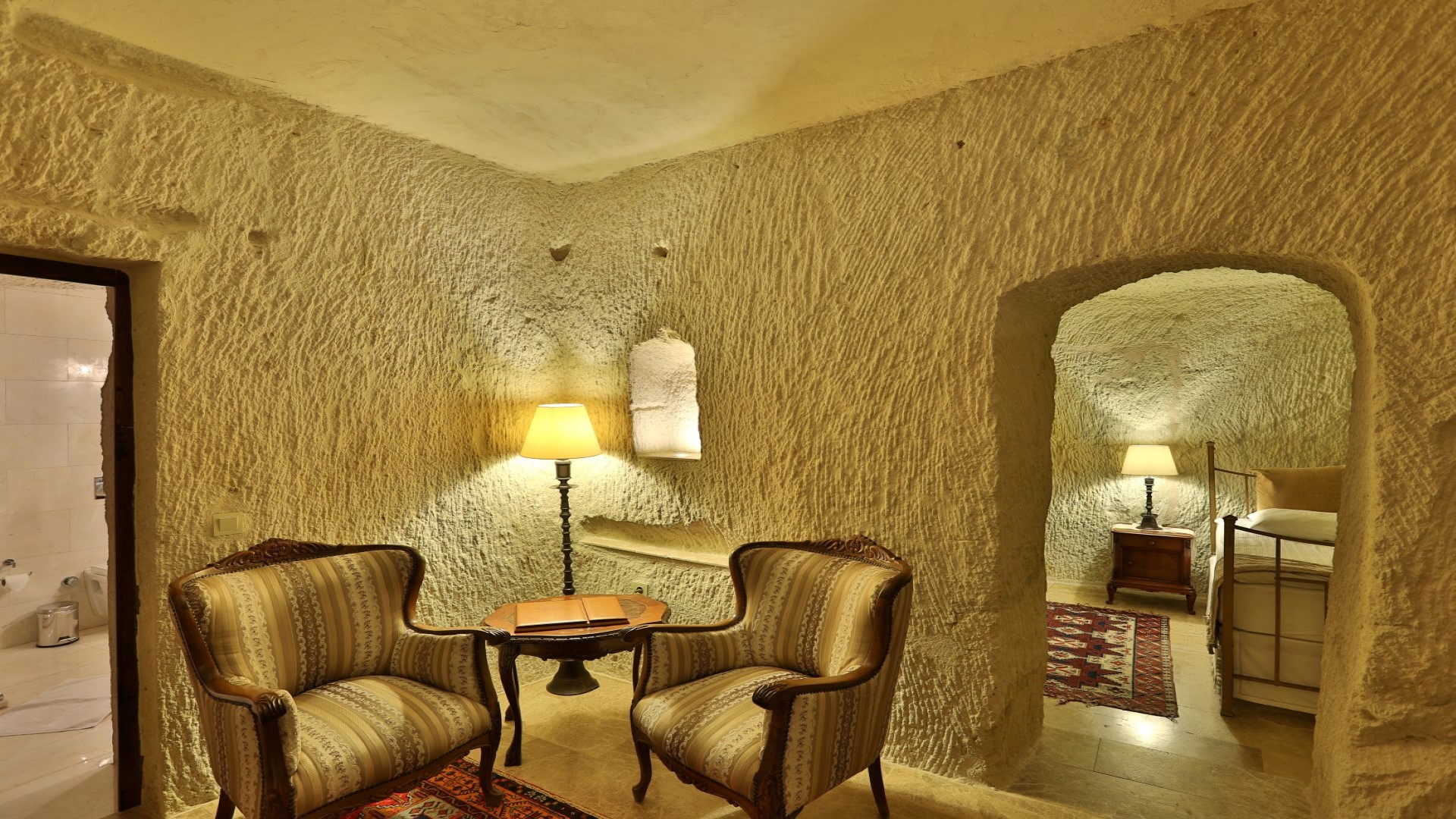 Spacious deluxe single room interior with living area at historic cave hotel