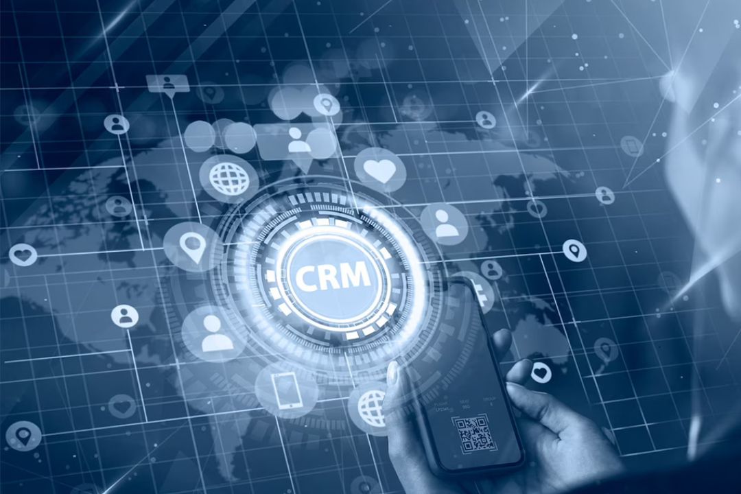  A user holds a phone displaying a digital CRM interface over a global map, highlighting the benefits of REI CRM systems from AMPLIFIREI.