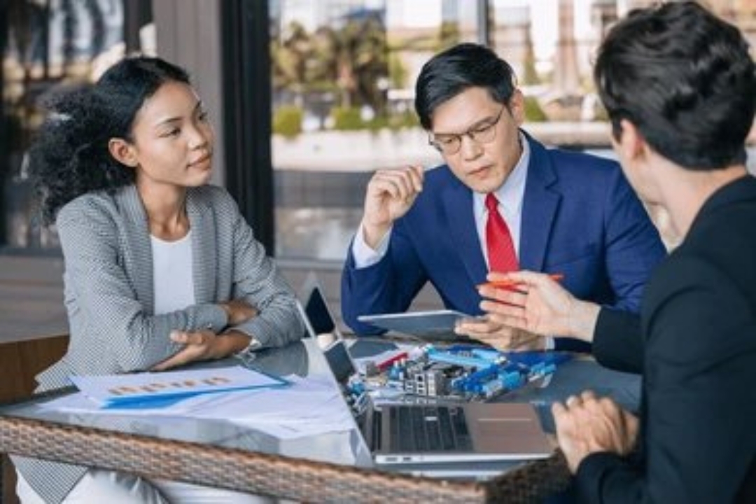 A smiling professional at a desk with house models and a calculator, representing the successful building an investor sales funnel with AMPLIFIREI. A smiling professional at a desk with house models and a calculator, representing the successful building an investor sales funnel with AMPLIFIREI.