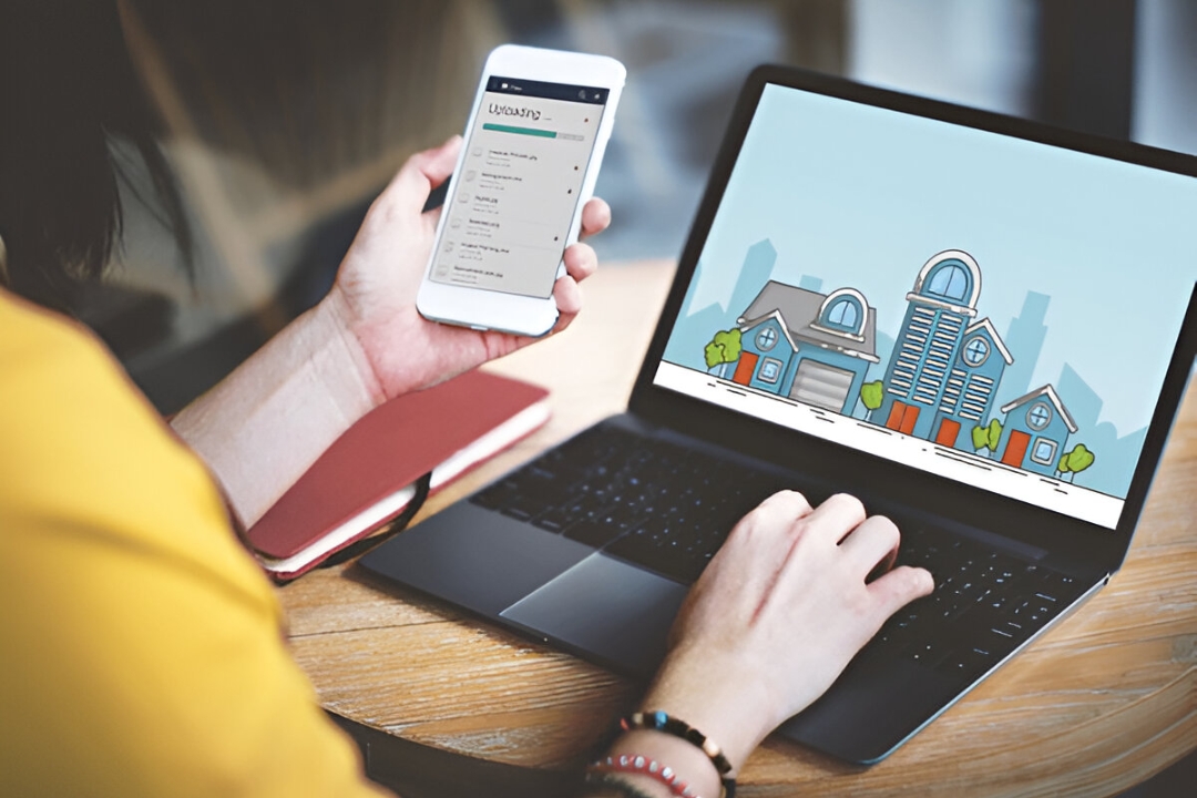  A real estate professional analyzes data on a tablet, with a laptop and house models, to execute AMPLIFIREI's process for creating a real estate marketing plan.