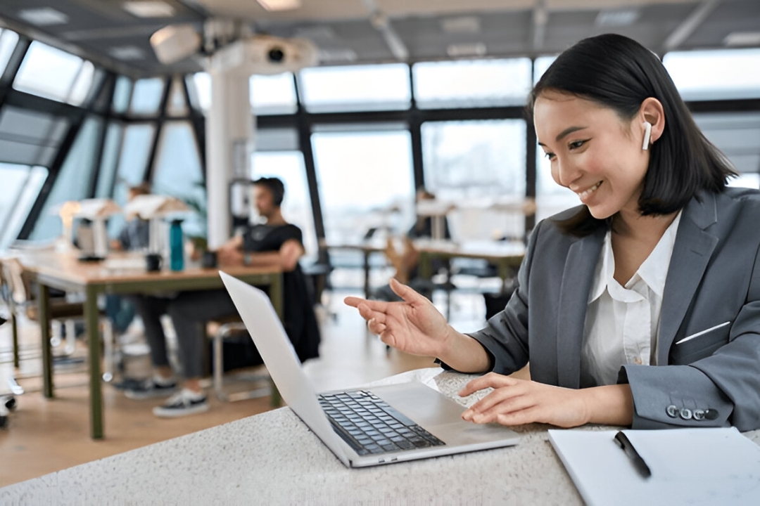 A woman smiles while on a video call using her laptop, showcasing call tracking benefits for REI by AMPLIFIREI. A woman smiles while on a video call using her laptop, showcasing call tracking benefits for REI by AMPLIFIREI.