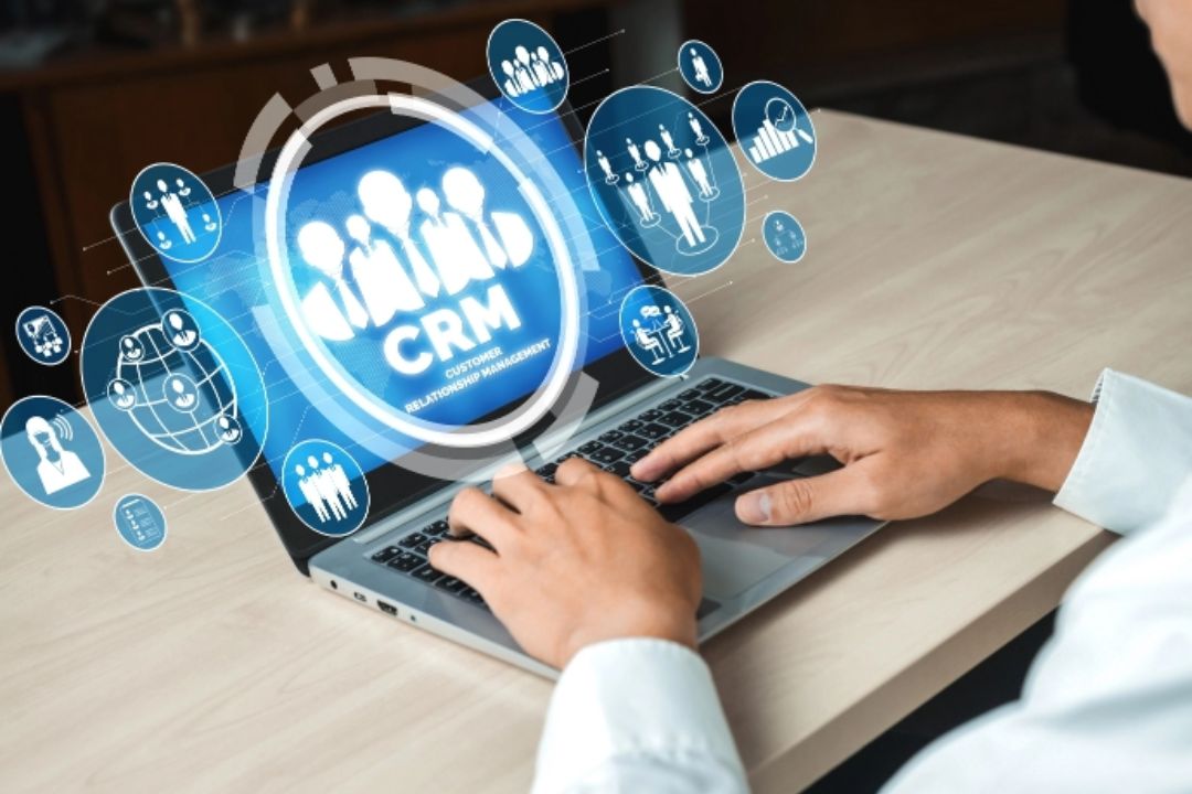 A business woman works on a laptop displaying "CRM" with customer icons, illustrating AMPLIFIREI's virtual real estate marketing tools. A business woman works on a laptop displaying "CRM" with customer icons, illustrating AMPLIFIREI's virtual real estate marketing tools.