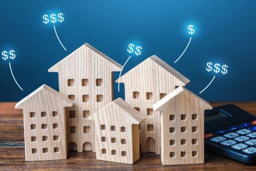 Various sized wooden houses with dollar signs show improving conversion rates in REI, with a calculator from AMPLIFIREI.