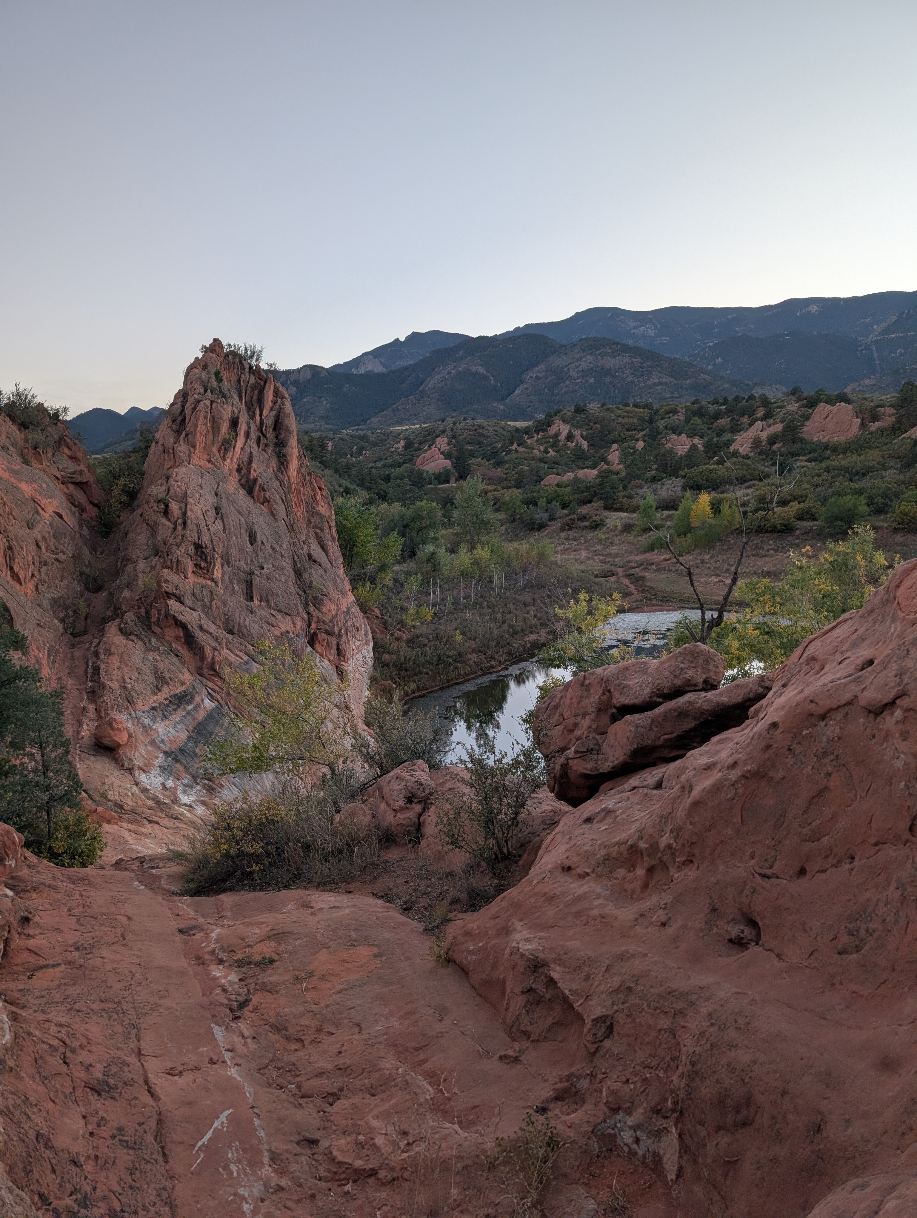 Hiking and Trails Guide for Colorado Springs Real Estate A hiker looking out over a valley in Colorado Springs, part of a guide to local trails and homes for sale.
