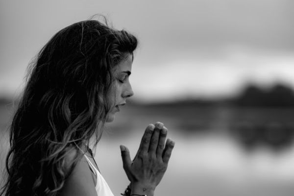 depressed sad-looking woman meditating or praying in black and white