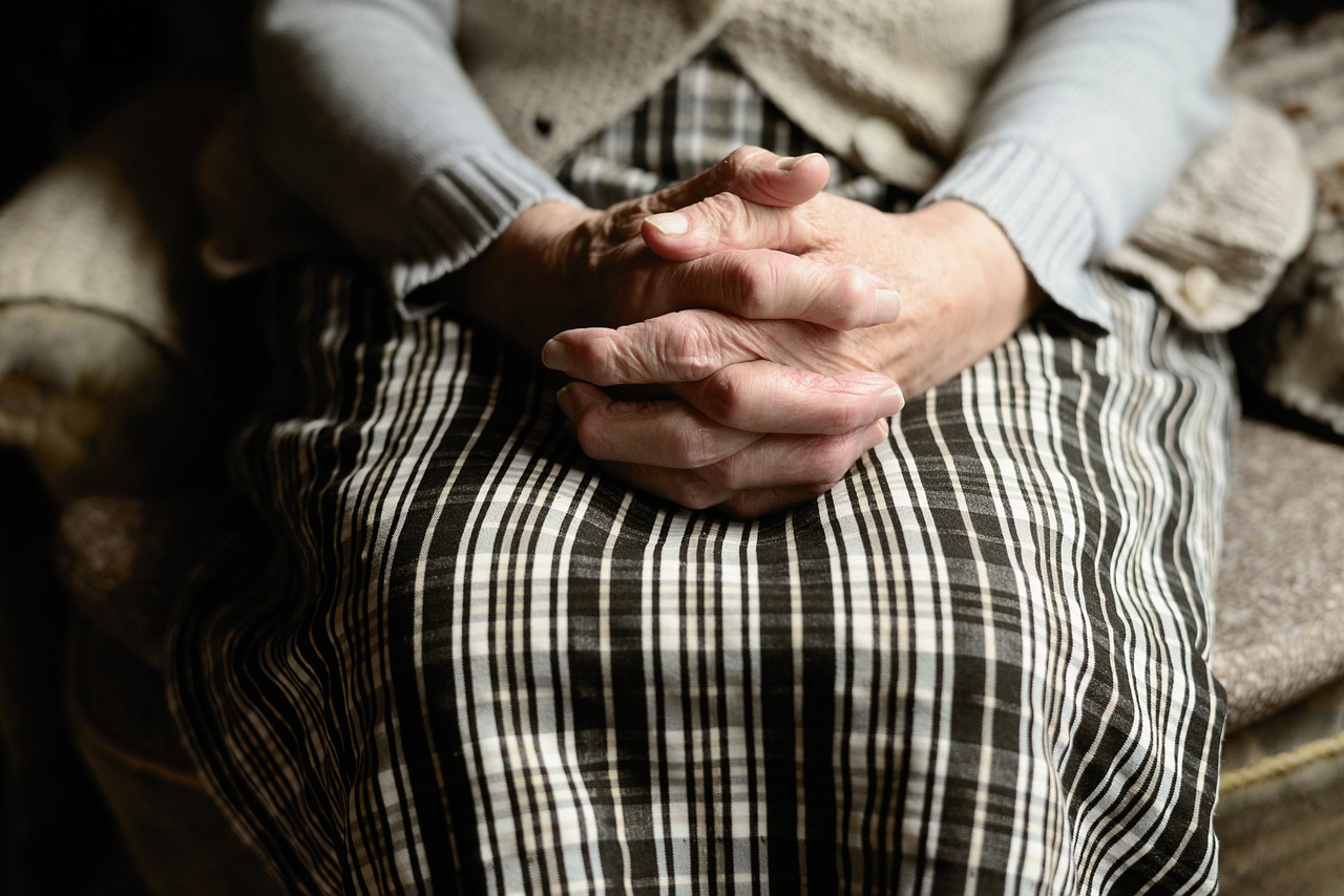old woman's hands in folded in her lap