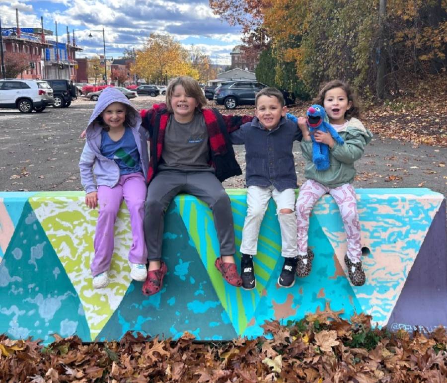 Children outdoors in a community setting, relaxed and confident, representing experiential learning and connection.