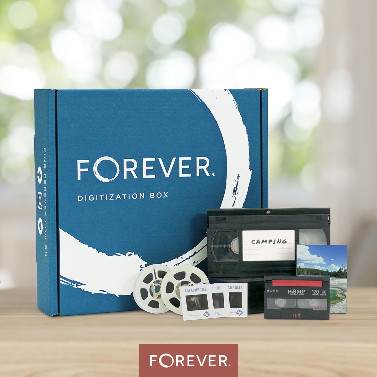 FOREVER® Digitization Box displayed on a table with vintage media including VHS tape labeled 'Camping,' film reels, photo slides, and a Hi8 cassette—highlighting the types of vacation memories that can be digitized. FOREVER® Digitization Box displayed on a table with vintage media including VHS tape labeled 'Camping,' film reels, photo slides, and a Hi8 cassette—highlighting the types of vacation memories that can be digitized.