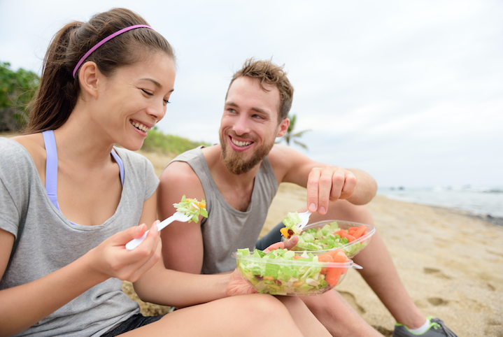 Two Healthy people eating salads after a workout