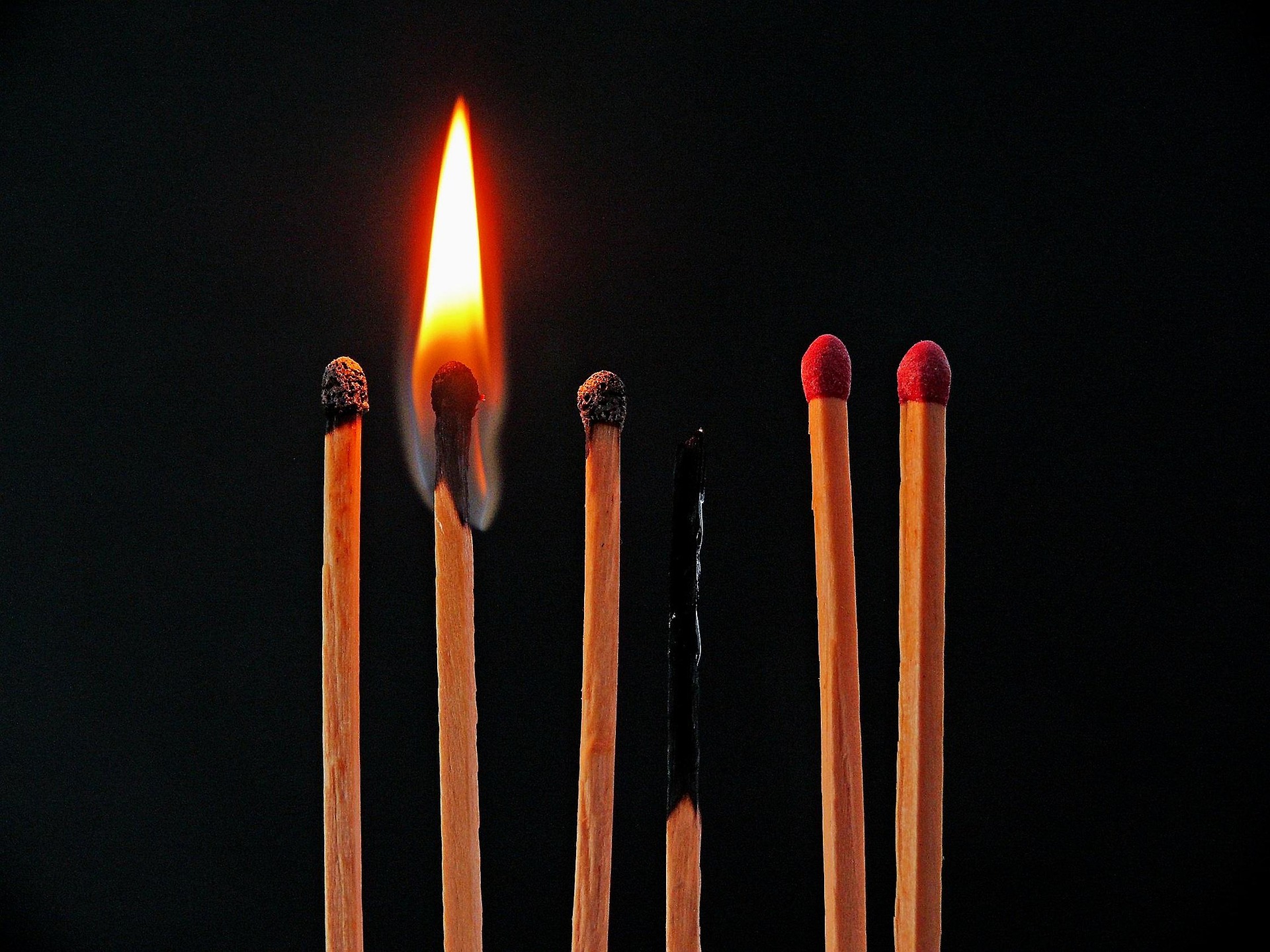 A row of matchsticks, with one lit and another burnt out, symbolizing burnout and the importance of healthy boundaries and self-care. A row of matchsticks, with one lit and another burnt out, symbolizing burnout and the importance of healthy boundaries and self-care.