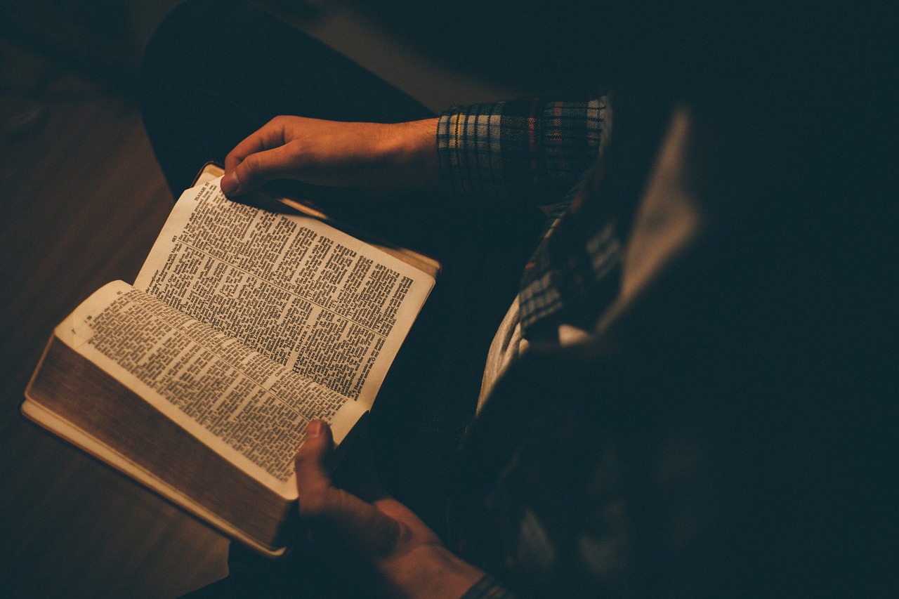 Person reading an open Bible in a quiet, dimly lit room, symbolizing personal time spent with God. Person reading an open Bible in a quiet, dimly lit room, symbolizing personal time spent with God.