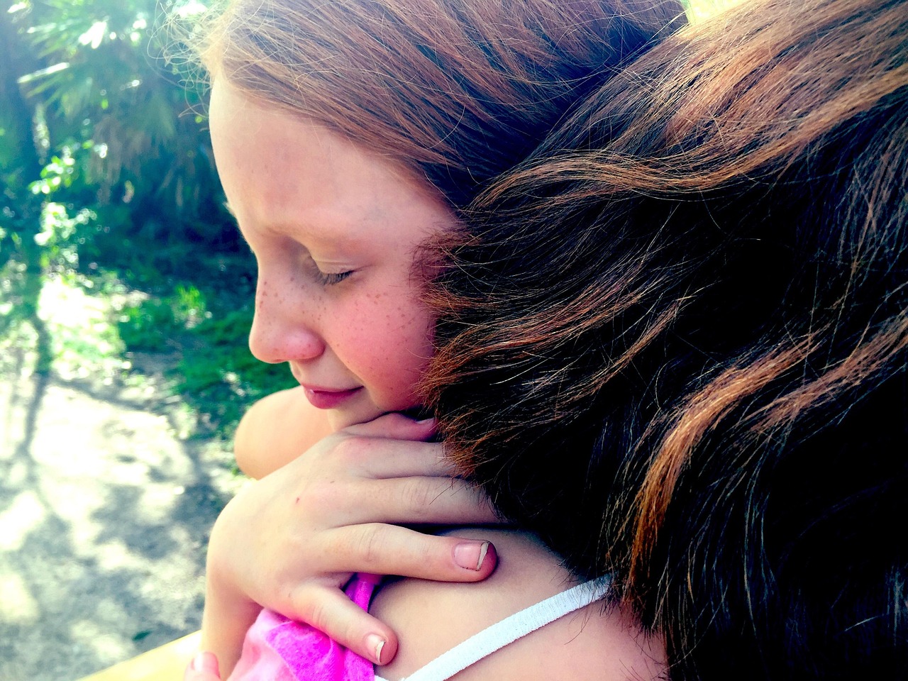 Two young girls hugging outdoors, eyes closed in comfort and forgiveness, symbolizing emotional healing, reconciliation, and the power of grace. Two young girls hugging outdoors, eyes closed in comfort and forgiveness, symbolizing emotional healing, reconciliation, and the power of grace.
