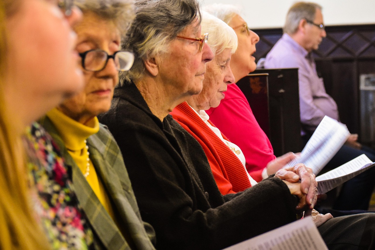 Elderly women praying and reading hymn books during a church service, symbolizing faith, devotion, and the power of communal prayer. Elderly women praying and reading hymn books during a church service, symbolizing faith, devotion, and the power of communal prayer.