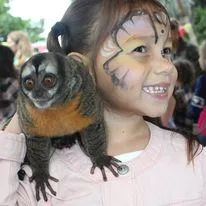 girl with face painted and monkey at festival