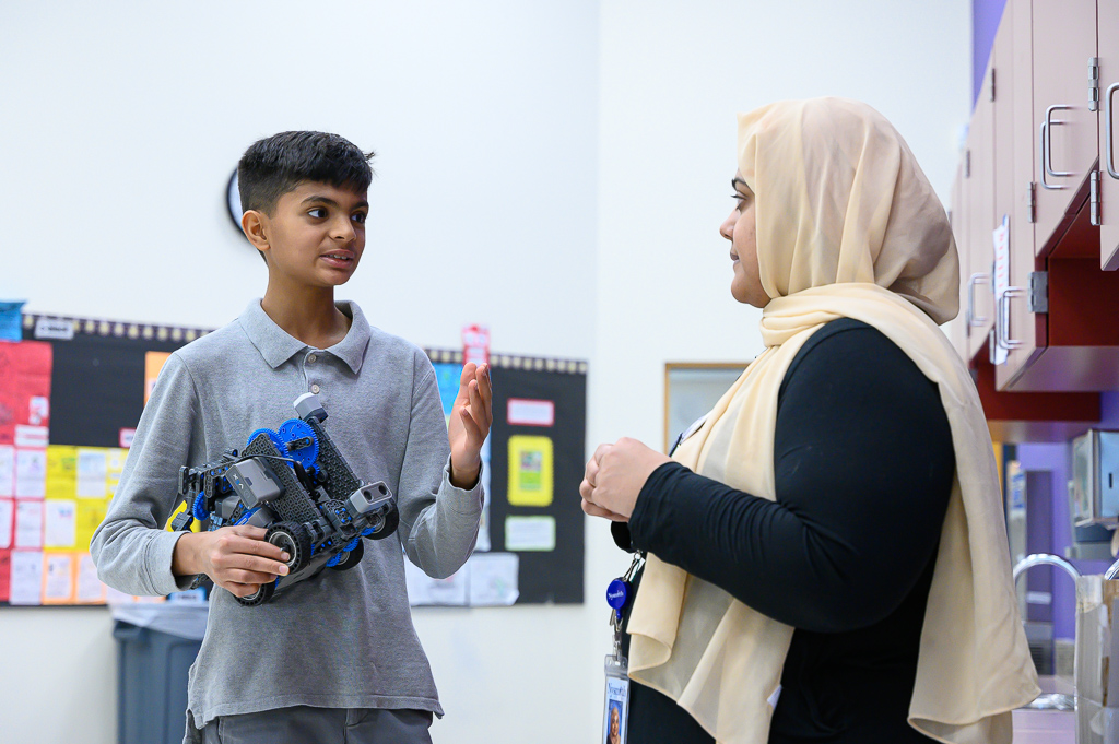 Student and teacher talking about how to resolve an issue with the student's robot. Student and teacher talking about how to resolve an issue with the student's robot.