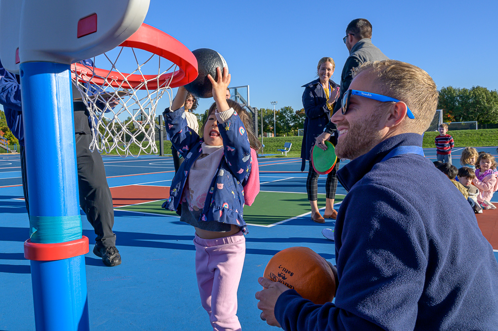 A teacher modeling how to shoot a basket for young student. A teacher modeling how to shoot a basket for young student.