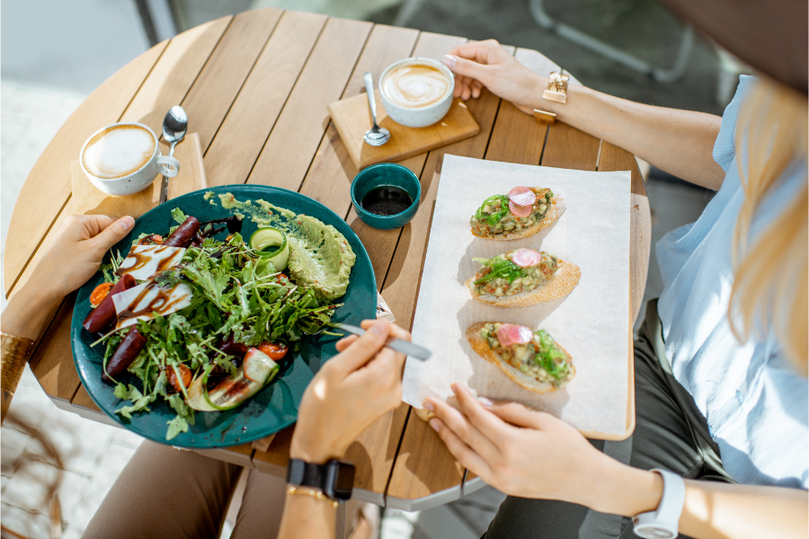 two people sharing a meal of salad and tapas