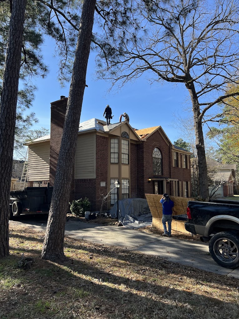 Team installing shingles with safety harnesses