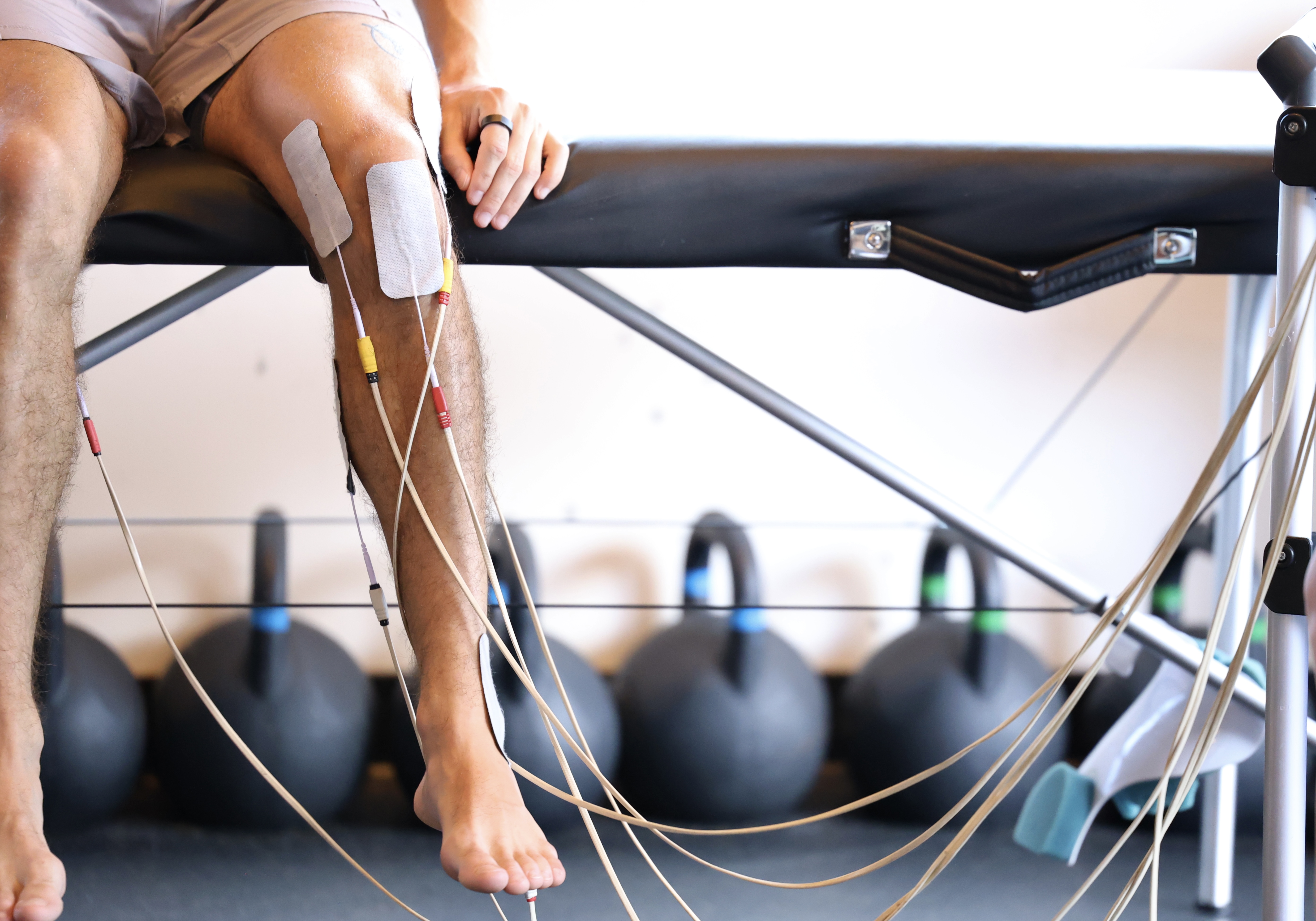 a client with neuromuscular stimulation pads on his knee