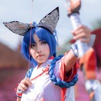 girl in cosplay with blue wig drawing and aiming a bow