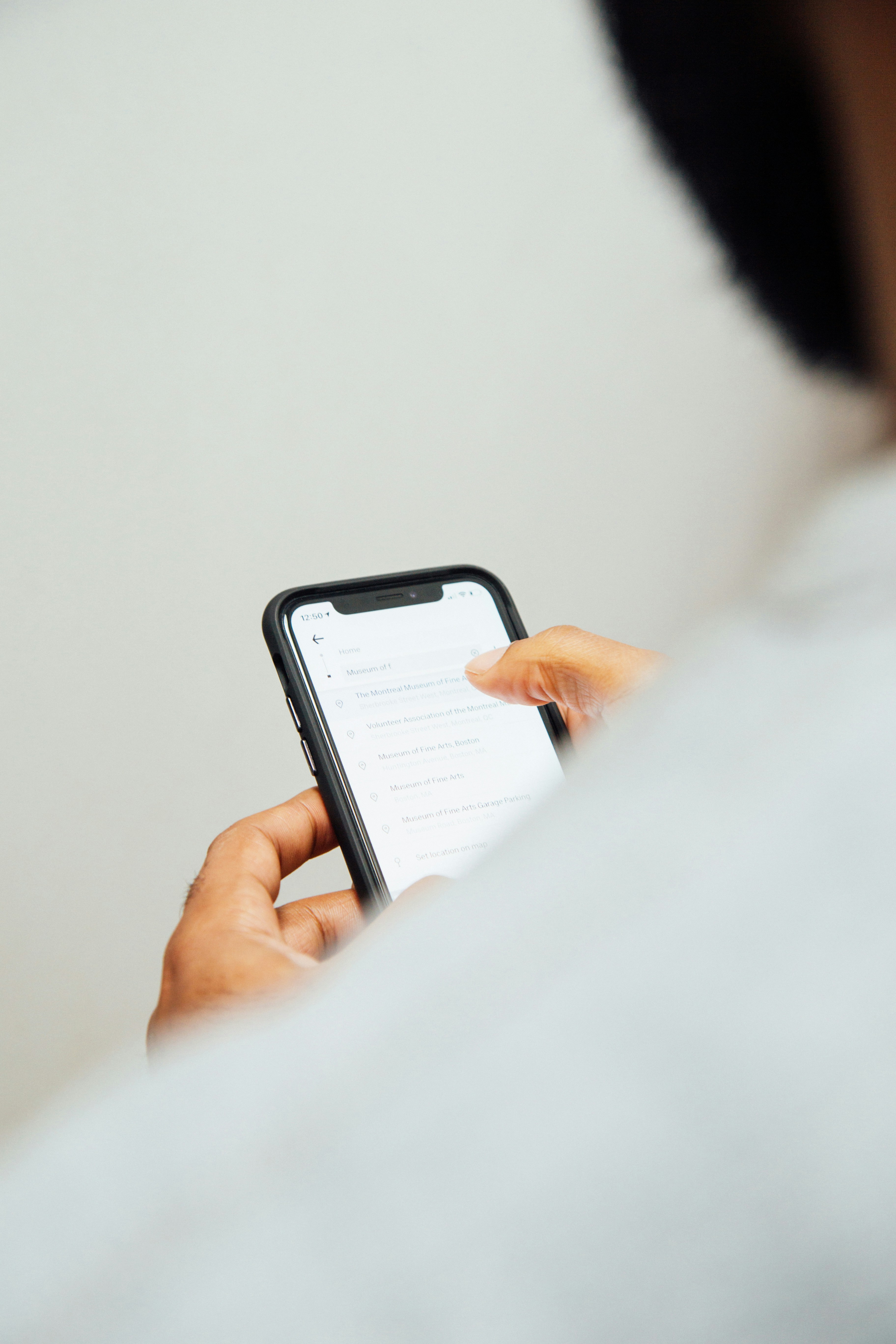 man-in-white-top-holding-iphone