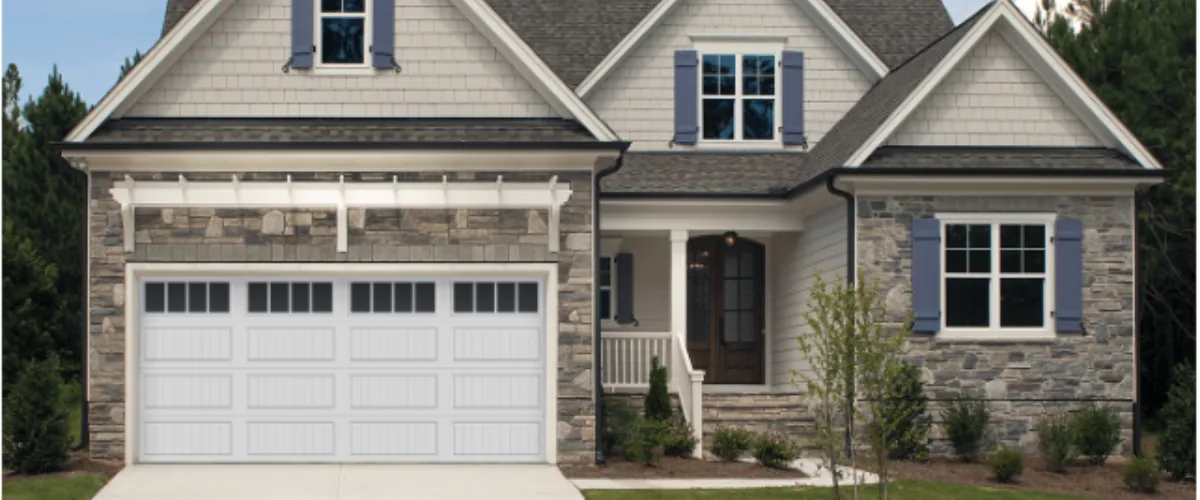 Stone-front home with white garage door, front porch, and gray shutters.
