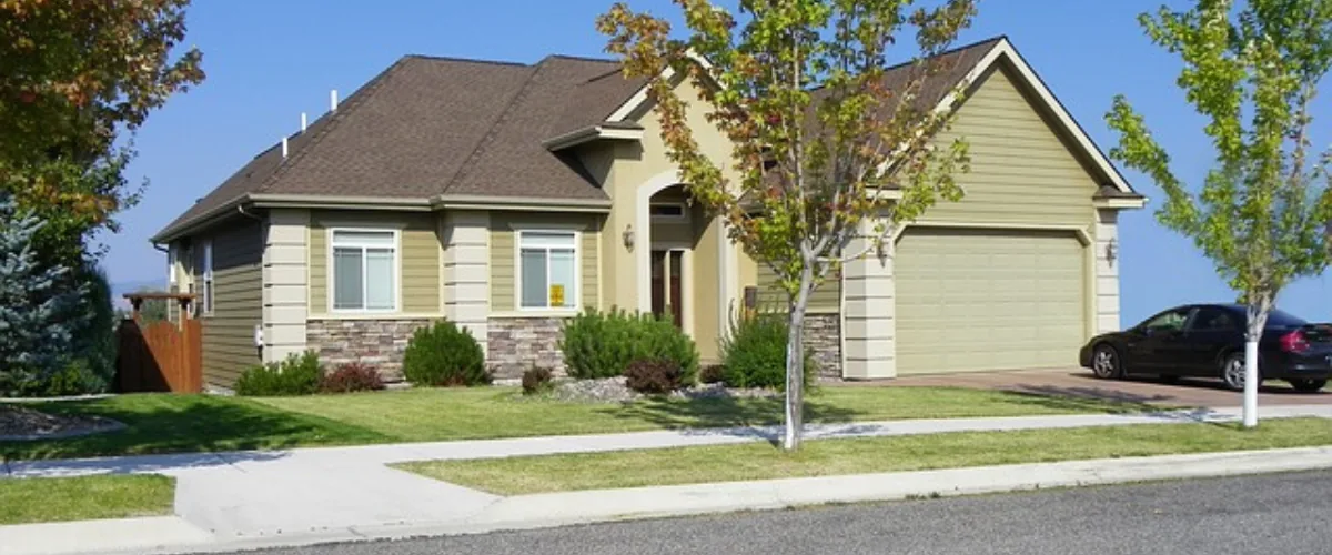 Suburban single-story home with attached garage, driveway, and front yard landscaping.