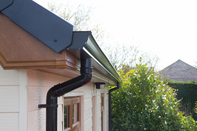 Seamless gutter installation by Masterpiece Roofing in Holliston, Massachusetts, providing efficient water management and sleek home design.